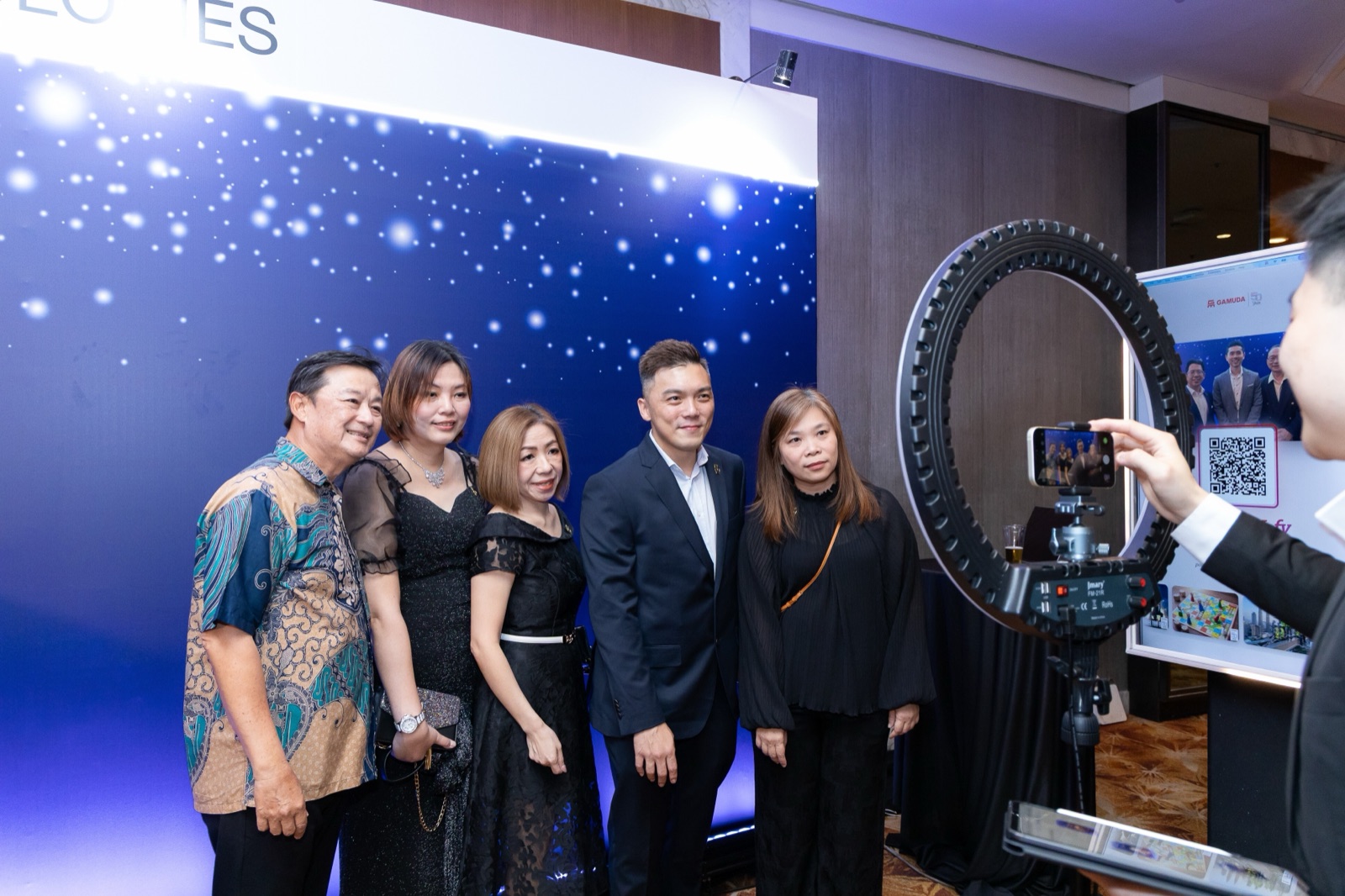 Guests posing at a Gamuda event with Auragram AI photobooth outputs